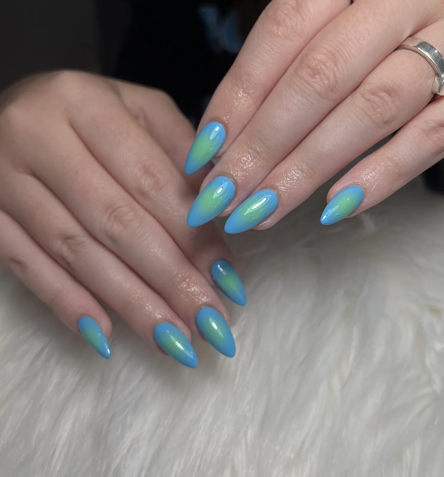 Sky blue almond nails with soft green airbrush aura accents